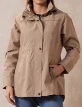Campera impermeable color gris claro, marca Gallery. Tiene abertura central con cierre oculto y botones a presión, bolsillos delanteros y capucha plegable en el cuello.