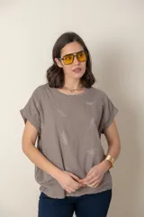 Blusa italiana color celeste con bordado de plumas al tono en el frente, confeccionada en lino y algodón.