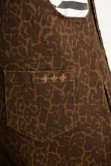 Enterito marrón con estampado animal print, breteles regulables, bolsillo en el pecho y corte ancho.