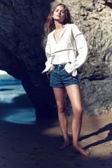 Short de jean de tiro alto con bordados de flores rojas, amarillas y blancas.