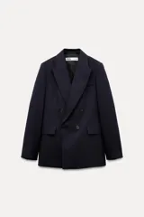 Blazer de lana azul marino con cuello solapa de muescas y manga larga acabada en abertura y botones. Tiene bolsillos con solapa en delantero y de vivo en pecho, forro interior a tono y cierre frontal cruzado con botones.