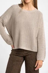 Sweater color beige de tejido de punto calado con lurex, de corte holgado y cuello redondo.