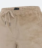 Bermuda masculina tipo runner color beige, confeccionada en terciopelo acanalado, con cintura elástica, cordón de ajuste y bolsillos laterales.