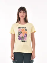 Remera amarilla con estampado de flores en tonos rosa, naranja y violeta.