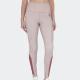 Calza deportiva ajustada color beige claro, con cintura alta. Presenta recortes laterales con microperforaciones y paneles en color bordó en la parte inferior de las piernas.