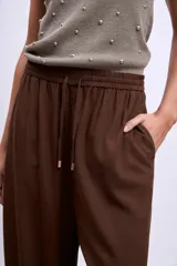 Pantalón palazzo marrón de tiro alto con cintura elastizada y cordón ajustable.