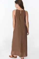 Vestido largo blanco de lino, sin mangas y con bolsillos laterales.
