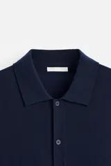 Camisa de punto azul marino, corte regular fit, tejida en hilatura con mezcla de lyocell. Cuello solapa, manga larga con acabados en rib y cierre frontal de botonadura.
