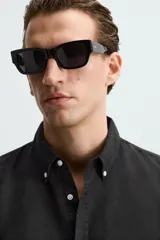 Camisa celeste a rayas verticales, de corte relaxed fit, confeccionada en lino y algodón. Tiene cuello abotonado, manga larga con puños abotonados, bolsillo de parche en el pecho y cierre frontal con botones.