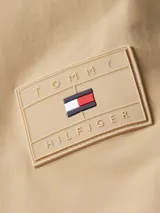 Campera color beige de Tommy Hilfiger, con cuello alto y cierre de cremallera. Tiene dos bolsillos laterales y logo engomado de Tommy Hilfiger bordado en la manga.