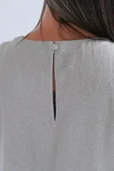 Vestido corto color gris plata, de lino italiano con brillo sutil, escote redondo y corte ligeramente acampanado.