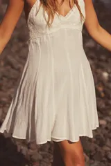 Vestido corto blanco de escote pico y tirantes finos ajustables. Detalle de bordados a tono. Forro interior. Cierre lateral con cremallera oculta en costura.