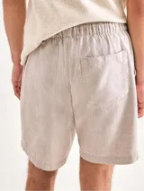 Bermuda verde de tela texturizada con cintura elastizada y cordón de ajuste.