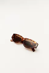 Lentes de sol negros con forma ovalada y patillas gruesas.