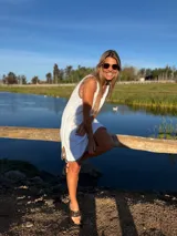 Vestido corto blanco tejido en hilo de algodón con detalles de crochet en contraste en el contorno.