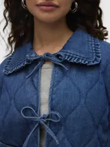 Campera de denim azul con cuello tipo spread collar, bolsillos delanteros, forro completo y acolchado ligero. Confeccionada en tejido sastrero twill con 80% algodón y 20% poliéster, presenta un acabado enzyme wash para una textura más suave y un efecto stonewash que aporta un look desgastado y vintage.