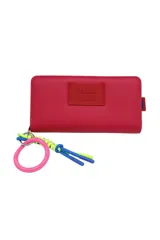 Billetera fucsia con cierre de cremallera y llavero con aro de goma rosa y cordones azul y verde.
