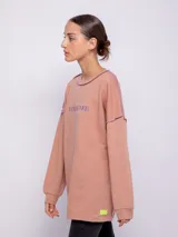 Buzo oversize de tela deportiva color salmón con bordado frontal y costuras a contra tono.