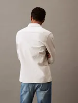 Camisa de manga larga color blanco hueso, confeccionada en lino y algodón. Tiene cuello clásico, cierre con botones y un bolsillo en el pecho.