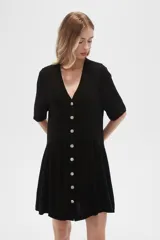 Vestido corto color crema, de corte holgado, con cuello en V y botones frontales.
