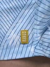 Short de baño verde con estampado de margaritas blancas y cordón ajustable naranja.