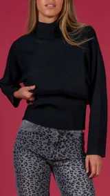 Sweater negro de manga larga con detalles de flecos en la parte inferior.