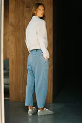 Pantalón de jean azul oscuro, corte carrot, tiro medio, largo cropped, con cintura elástica en la parte trasera, bolsillos delanteros y traseros, cierre con cremallera y botón.