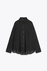 Camisa color durazno confeccionada en algodón, de corte amplio, con cuello solapa, manga larga con puños abotonados, hombros caídos, bolsillo de parche en el pecho, pinzas en la espalda y cierre frontal con botones.