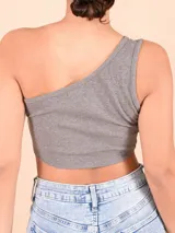 Blusa blanca de un solo hombro, corte crop top y tejido acanalado.