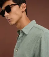 Camisa de hombre color verde menta, confeccionada en algodón texturizado con patrón melange. Presenta cuello inglés, manga larga y abotonado frontal. El corte es de estilo comfort, más generoso en sus medidas para mayor comodidad.