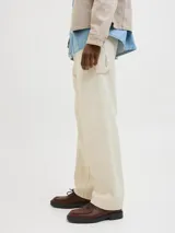 Pantalón jean color crema, corte amplio, con tiro alto, cinco bolsillos y cierre con botones.