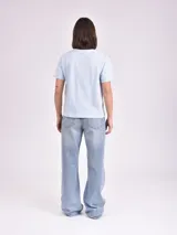 Remera celeste de algodón con estampado de flor y texto "Real View".
