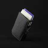 Billetera doble de tela X-Pac negra con doble caja de aluminio incorporado con sistema de deslizamiento para tarjetas. Tiene espacio para 10 tarjetas, 2 tarjetas adicionales en los bolsillos laterales de cuero, espacio para libreta de conducir y de propiedad, y sección interna para llevar hasta 5 billetes.