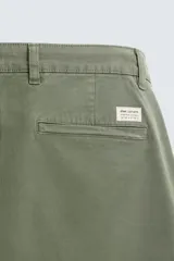 Pantalón chino color beige, corte skinny fit, confeccionado en tejido con mezcla de algodón y elasticidad. Cuenta con bolsillos frontales y traseros. Cierre frontal con cremallera y botón.
