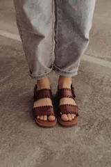 Sandalias de cuero marrón con tiras tejidas a mano y costuras a la vista.