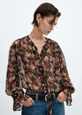 Blusa semitransparente con estampado floral, de tejido fluido y diseño recto, con cuello pico y mangas largas abullonadas.