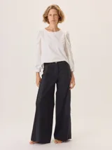 Pantalón de pierna ancha color azul marino con pespuntes a contratono (rojo/bordó) y una tira contrastante en el lateral.