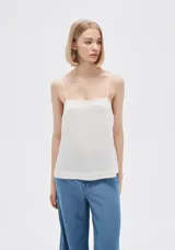 Blusa blanca de lino con breteles finos y escote recto.