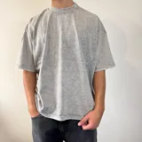 Remera gris con efecto nevado, corte cuadrado y cuello redondo.