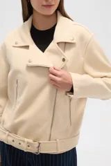 Chaqueta negra con cuello solapa, cierre cruzado con cremallera, cinturón con hebilla, bolsillos laterales con cremallera y detalles de botones metálicos.