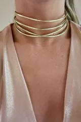 Gargantilla rígida dorada de bronce, con cuatro aros superpuestos, uno de ellos cruzado.