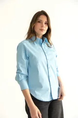 Camisa celeste de corte clásico con bolsillo en el pecho y botones al tono.