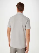 Camiseta tipo polo de manga corta, color azul oscuro, con cuello y tapeta de dos botones.