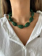 Collar de cuentas grandes y ovaladas de resina verde con vetas oscuras, tipo piedra malaquita.
