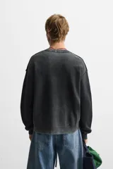 Sweater negro de algodón con cuello redondo, manga larga y terminaciones en rib.