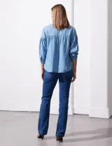 Blusa celeste de lyocell con cuello a la base, escote en V con botones y mangas 3/4 con puño abotonado.