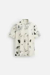 Camisa de manga corta con cuello bowling y estampado floral en tonos blanco y negro.