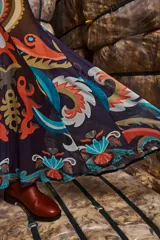 Falda larga de tul estampada con motivos paisley en tonos azul, naranja y marrón. Tiene drapeado en la cadera, corte evasé y cintura elástica.