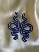 Aros colgantes con forma de serpiente azul contorneada con strass.