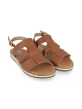 Sandalias color camel con capellada de cuero, suela blanca y ajuste con hebilla.